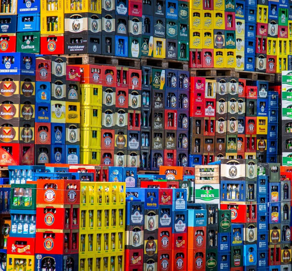 A vibrant display of beer crates stacked in a warehouse, showcasing various brands.
